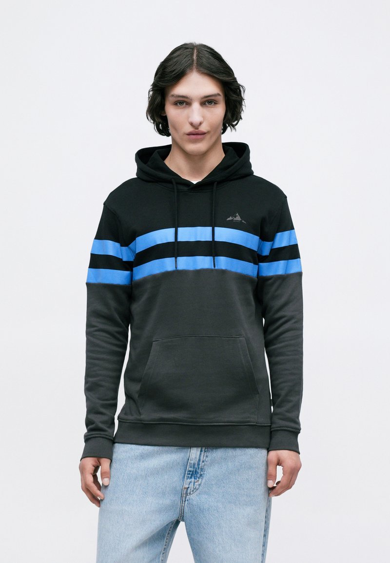 O hoodie preto apresenta riscas azuis horizontais, bolso canguru e capuz ajustável com cordão. Feito de um tecido macio e texturizado.