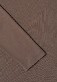 Tissu marron côtelé montrant une manche avec un ourlet net. Le matériau semble doux avec un motif texturé de lignes verticales.