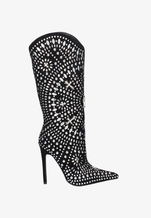 Bota negra hasta la rodilla con punta afilada, adornada con tachuelas plateadas y acentos brillantes, con un elegante tacón de aguja.