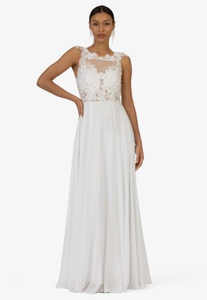 Weißes Kleid mit einem durchsichtigen, floralem Spitzen-Oberteil und einem fließenden, glatten Rock. Merkmale sind das ärmellose Design und die aufwendige Blumenstickerei am Halsausschnitt.