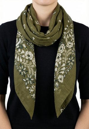 Sciarpa verde oliva con motivi floreali bianchi e verde scuro, drappeggiata e avvolta liberamente intorno al collo sopra una canotta nera.