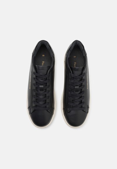 Sorte lærersneakers med runde tæer, flade sorte snørebånd og en gummisål. Indvendigt har de blød sort foring og diskret branding i guld.