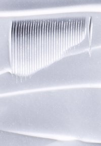 Material de silicona blanca con una textura lisa y brillante. Presenta un borde curvo y suave, así como una sección estriada con líneas paralelas que crean un patrón.