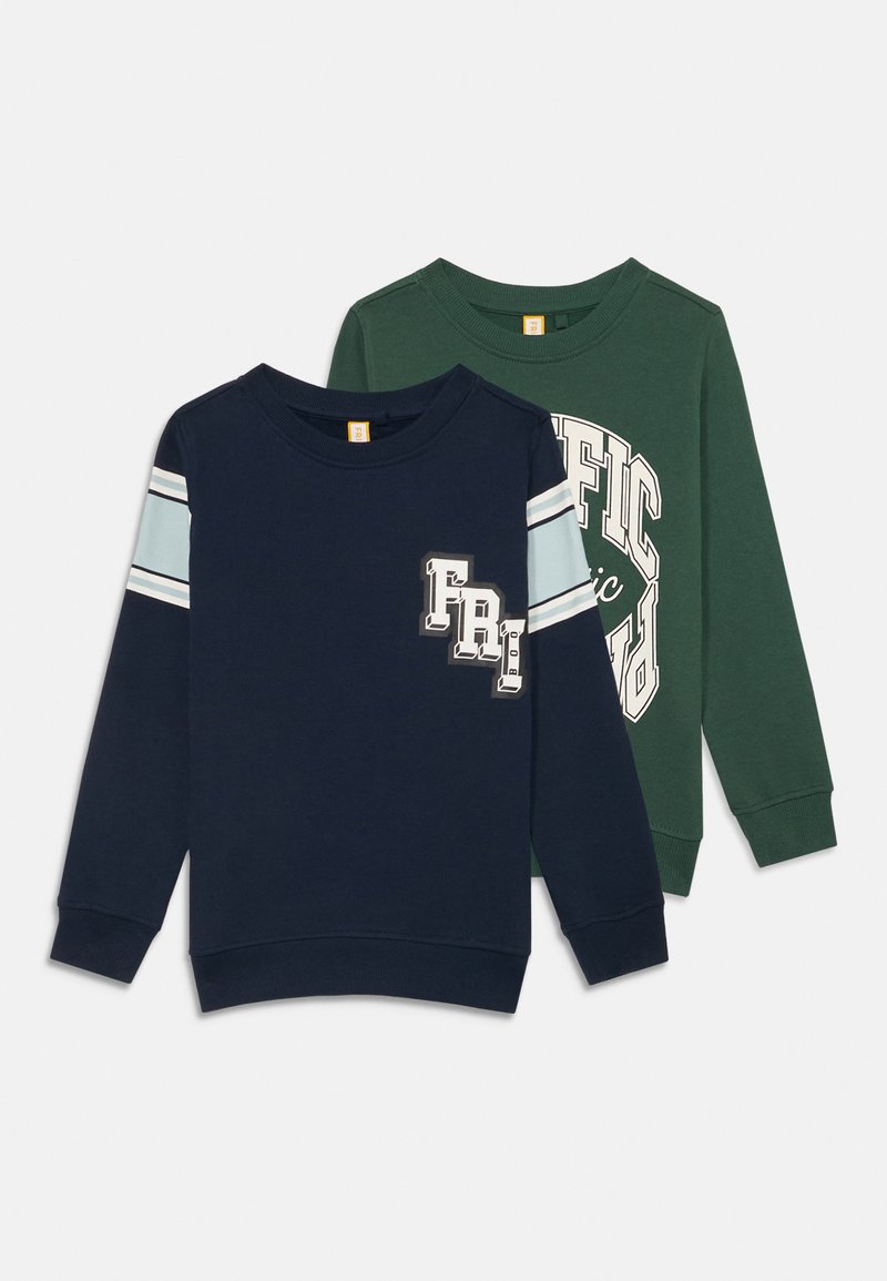 Deux sweatshirts à manches longues, l'un bleu marine avec des rayures bleu clair et un motif graphique, l'autre vert avec un grand design en texte blanc. Tissu en coton.