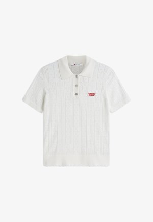 Wit gebreide poloshirt met korte mouwen, een gestructureerd patroon, drie knopen, geschulpte randen en een klein rood "tommy jeans"-logo op de borst.