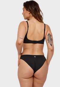 Schwarzes Bikini-Set mit einem schlichten Design, verstellbaren Trägern und einem Hakenverschluss. Die Textur wirkt glatt mit minimaler Markenkennzeichnung.