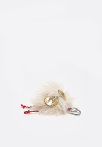 Accesorio de llavero esponjoso de color crema con dos botones dorados brillantes, asegurado por cordones rojos y un mosquetón plateado. Textura suave, forma redonda.