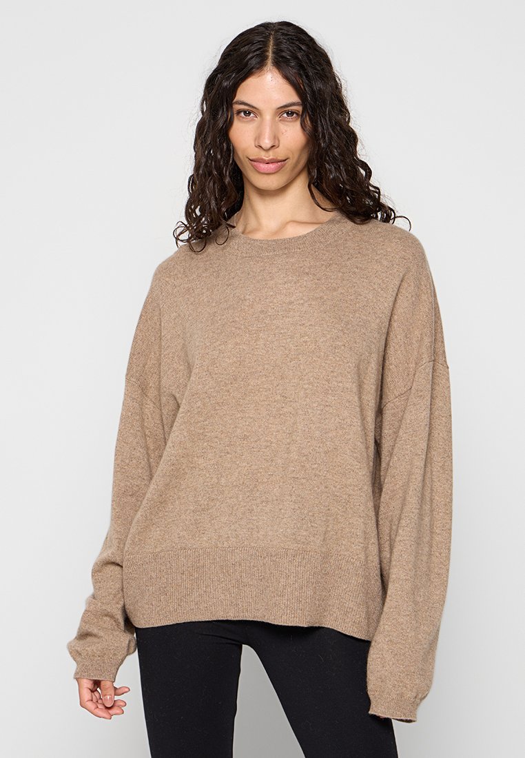 Maglione oversize marrone con scollatura rotonda, orlo a coste e maniche lunghe. Realizzato in materiale morbido e testurizzato.