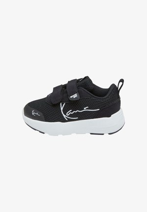Pantofii sport negri cu upper din plasă, cu două curele Velcro, talpă albă și accente proeminente ale logo-ului în alb pe lateral și pe limba pantofului.