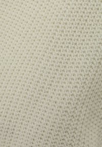 Gebreide stof in een zachte witte kleur met een gestructureerd patroon, gekenmerkt door een dichte, in elkaar grijpende steekstructuur. Gladde en flexibele textuur.