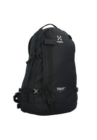 Mochila negra con un tejido duradero, correas ajustables, un diseño curvado y un logotipo en la parte frontal; incluye múltiples hebillas y compartimentos.
