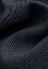 Tela texturizada de color azul oscuro con un acabado suave y tejido, que exhibe costillas finas y pliegues suaves y fluidos.