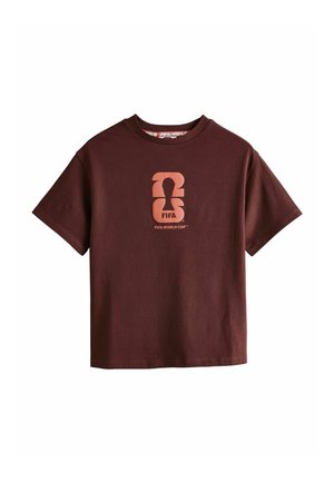 Mørkebrun kortærmet T-shirt med abstrakt FIFA World Cup-trofælogo og tekst centreret på brystet.