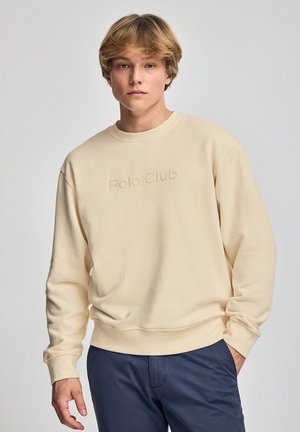 Sudadera beige con cuello redondo, con el texto en relieve "Polo Club" en la parte frontal, fabricada en un tejido suave y texturizado. Mangas largas.