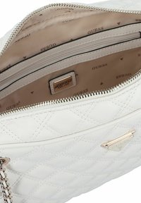 Borsa a tracolla bianca trapuntata con esterno in pelle liscia, zip in tonalità argento e placca con logo Guess all'interno di un rivestimento in tessuto beige.