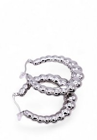 Orecchini a cerchio in argento con un design a perline spesso e una finitura lucida. Le chiusure sono trasparenti e discrete, garantendo una vestibilità sicura.