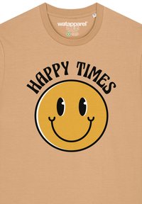 Beige katoenen T-shirt met een grote gele glimlachende gezichtsgrafiek met brede ogen, boven de tekst "HAPPY TIMES" in vetgedrukte zwarte letters.