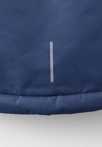 Marinblå vadderad tyg med en slät yta, med en enda vertikal reflekterande rand nära fållen.