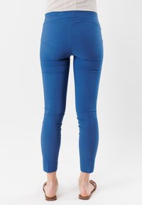 Pantaloni stretch blu con un design aderente e taglio alla caviglia. Texture liscia, vita elastica e silhouette snella. Senza tasche visibili.