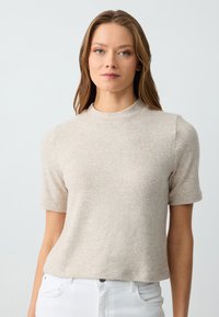 Maglione beige a maniche corte realizzato in un morbido tessuto testurizzato. Presenta un collo a giro e una vestibilità rilassata, adatto per un look informale.