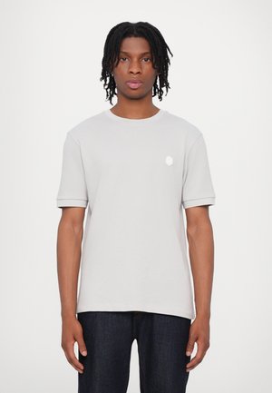 Light gray cotton t-shirt with short, rolled sleeves and a round neckline. Features a small white hexagon logo on the left chest.