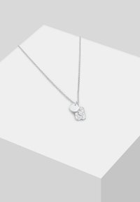 Silver necklace with a textured pendant and a circular charm, featuring a delicate chain and minimalist design on a light background.