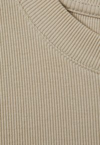 Beige ribbettyyppinen kangas, jossa on hienot pystysuorat raidat, pyöreä pääntie ja näkyvät ommeltyksensä yksityiskohdat. Pehmeä rakenne ja kevyt ilme.