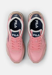 Sneakers rosa con tomaia sintetica, lacci bianchi, dettagli blu navy e suola in gomma marrone. Caratterizzati da un logo prominente sulla linguetta.