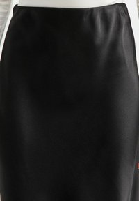 Jupe crayon en satin noir avec une texture lisse, un design épuré et une taille élastique pour un ajustement confortable.