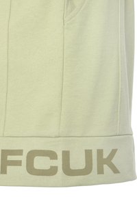 Light green sweatshirt featuring a soft texture, practical side pockets, and bold "FCUK" logo in a darker shade at the hem.