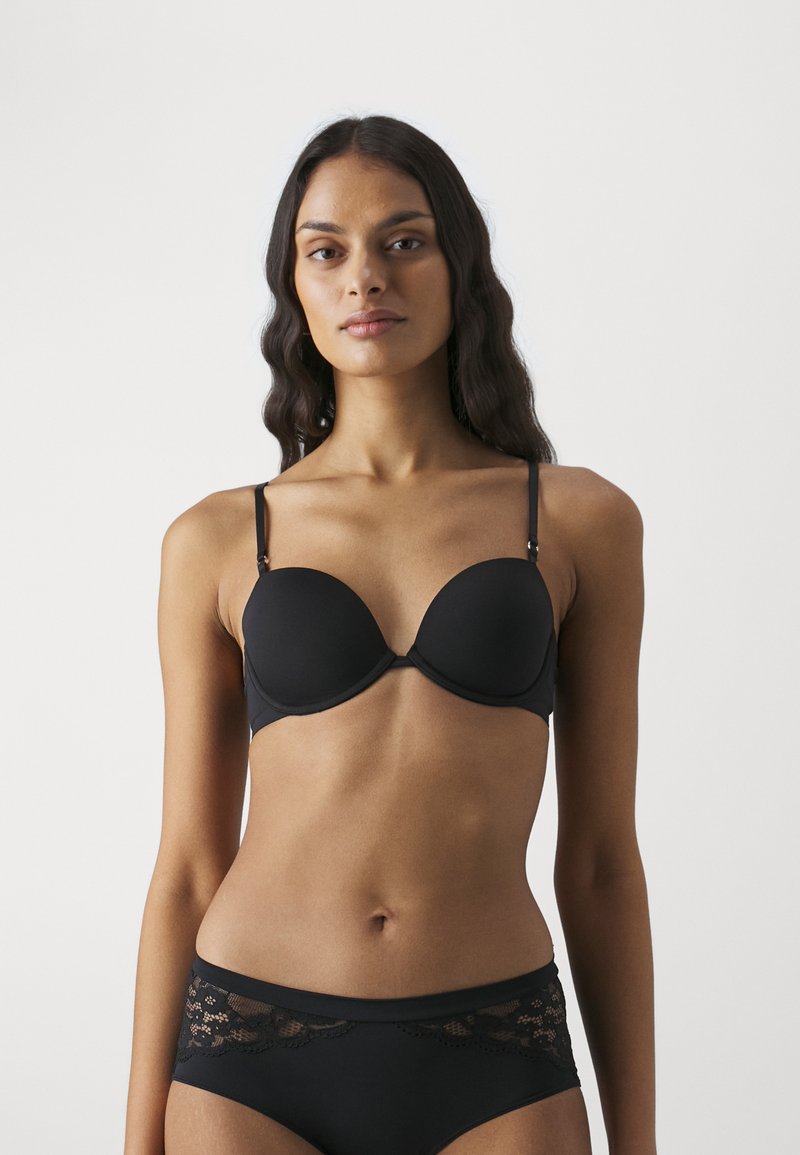 Black padded bra with adjustable straps, smooth texture, and seamless cups. Paired with matching black panties featuring lace accents.
