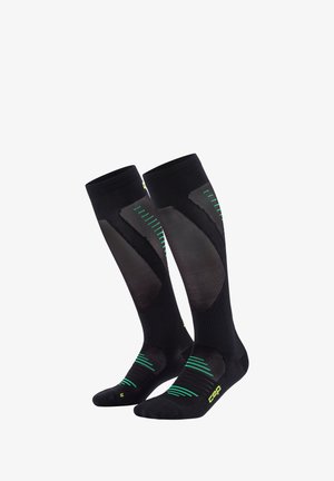 Black compression socks with green diagonal stripes and mesh panels, featuring a reinforced toe and arch support for comfort and support.