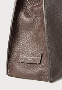 Brown leather handbag featuring a textured surface, stitched accents, and a label with "GIANNI CHIARINI FIRENZE" in white.