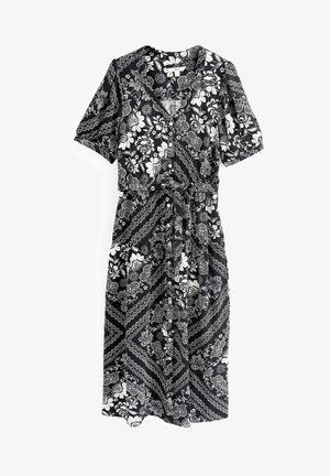 Robe noire avec motif floral blanc et chaîne, manches courtes, encolure en V et devant à boutons. Taille froncée et ourlet à hauteur du genou.