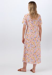 Lyhythihainen, keskikokoinen mekko kevyestä, pehmeästä kankaasta, jossa on vaaleanpunainen tausta ja monivärinen abstrakti leopardikuosi.