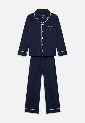 Temno modra bombažna pižama s srajco na gumb z belimi obrobami, prsno žepom in usklajenimi hlačami z elastičnim pasom ter logotipom.