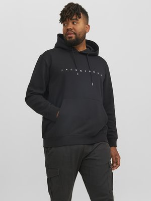 Black hoodie with a kangaroo pocket and drawstring hood, featuring a white "JACK & JONES" logo across the chest, made from soft fabric.