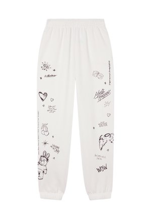 Pantaloni della tuta bianchi con scarabocchi neri e frasi scritte a mano come "La magia accade", cuori, dadi, ciliegie, ali e un orsacchiotto in tuta da coniglio.