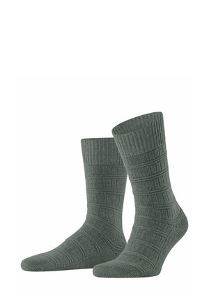 Grüne gerippte Socken mit einem strukturierten Muster, in mittellanger Knöchel- oder Wadenlänge und verstärktem Zehen- und Fersenbereich für zusätzliche Haltbarkeit.