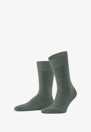 Grüne gerippte Socken mit einem strukturierten Muster, in mittellanger Knöchel- oder Wadenlänge und verstärktem Zehen- und Fersenbereich für zusätzliche Haltbarkeit.