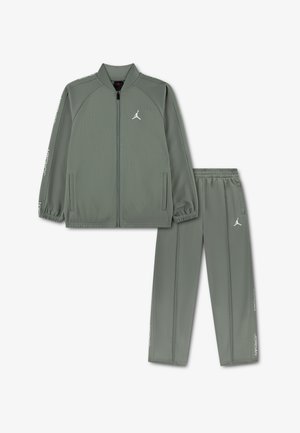 Veste de sport grise avec fermeture éclair complète, col côtelé et poches latérales, accompagnée d'un pantalon assorti avec une taille élastique et des accents de logo.