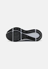 Black and white athletic shoe outsole with a textured pattern, featuring rectangular and diamond-shaped grips for traction.