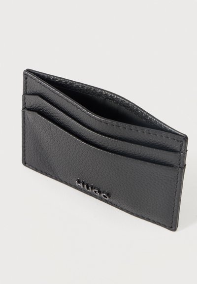 Porte-cartes en cuir noir texturé avec deux emplacements pour cartes et une poche centrale, embossé d’un petit logo "Hugo" sur le devant.