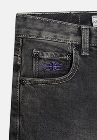 Tmavě šedé džínové kalhoty s malou přední kapsou se černými cvoky a fialovým prošíváním vlnkovým vzorem. Silná stonewash úprava.