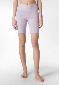 Lila högmidjade cykelbyxor i sträckt tyg, med en smidig yta och knälång klippning. Ingen framträdande mönster eller hårdvara.