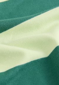 Material textil cu dungi verzi și galben deschis, având o textură moale și fină. Dungile sunt late și uniform distanțate, evidențiind o construcție tricotată.