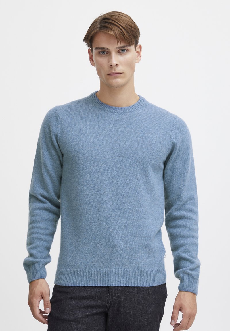 Light blue knitted sweater with a round neck, long sleeves, and ribbed cuffs and hem. Soft texture with a subtle, uniform pattern.