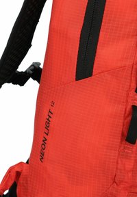 Zaino rosso con un motivo a reticolo, dotato di una tasca con zip e spallacci neri. Il marchio "NEON LIGHT 12" è stampato sul lato.