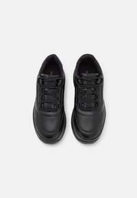 Svarta snörskor i slät läder med rund tå, vadderad tunga och texturerade detaljer på sidorna.