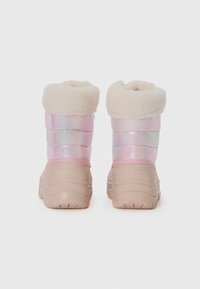 Bottes imperméables roses et irisées avec un col en fourrure crème, une semelle en caoutchouc et une texture matelassée. Conçues pour la chaleur et le confort.